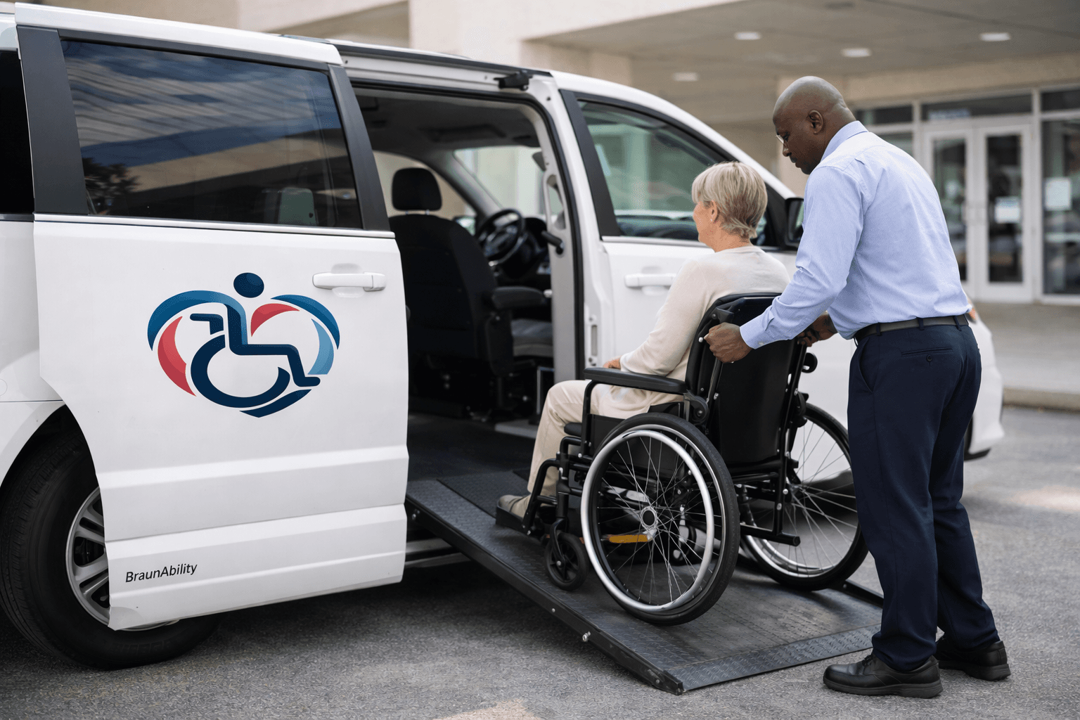 Wheelchair rider boarding a white BraunAbility XT transport van using a manual ramp with driver assistance.